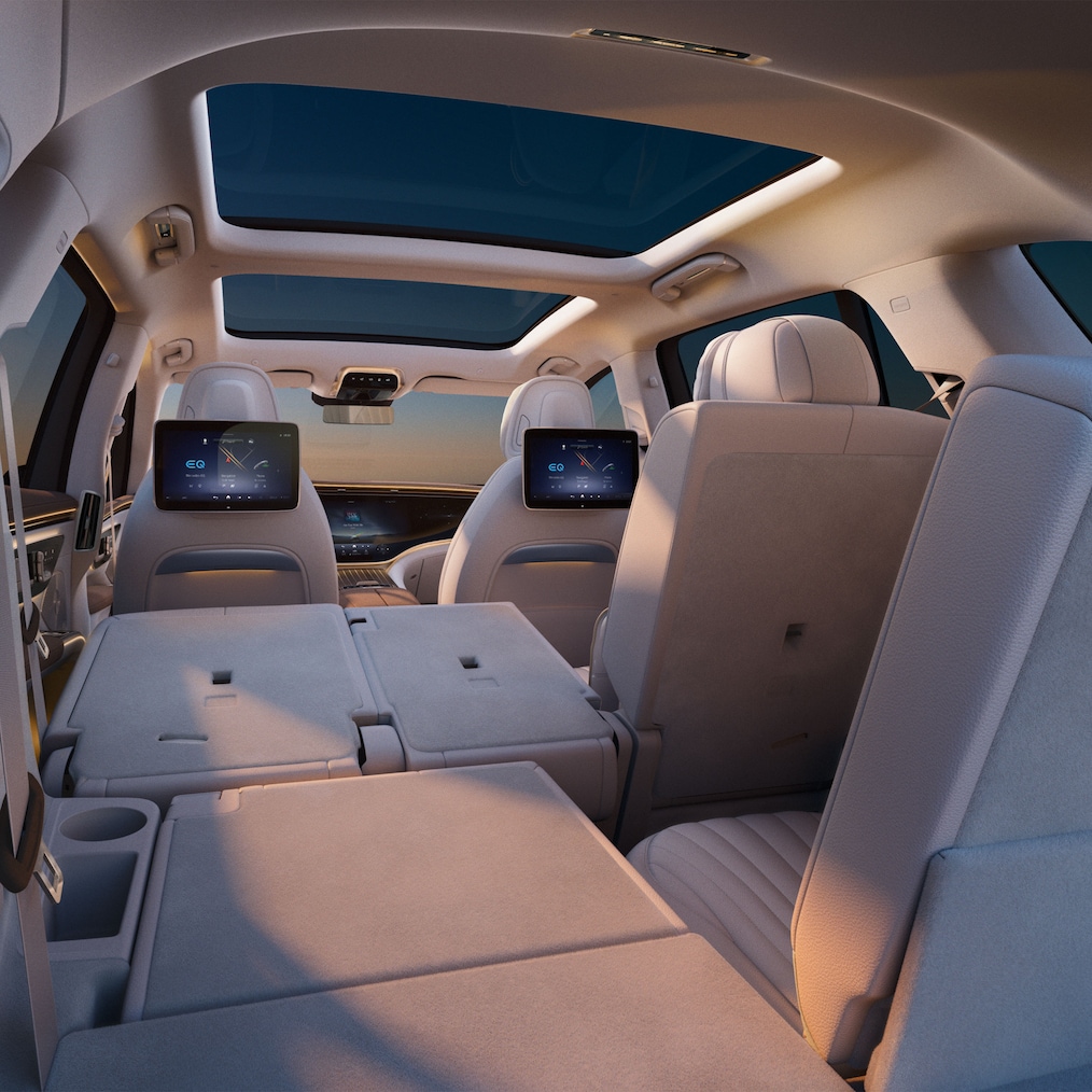 A view of the two rear rows of seats of the EQS SUV with the rear side door open.