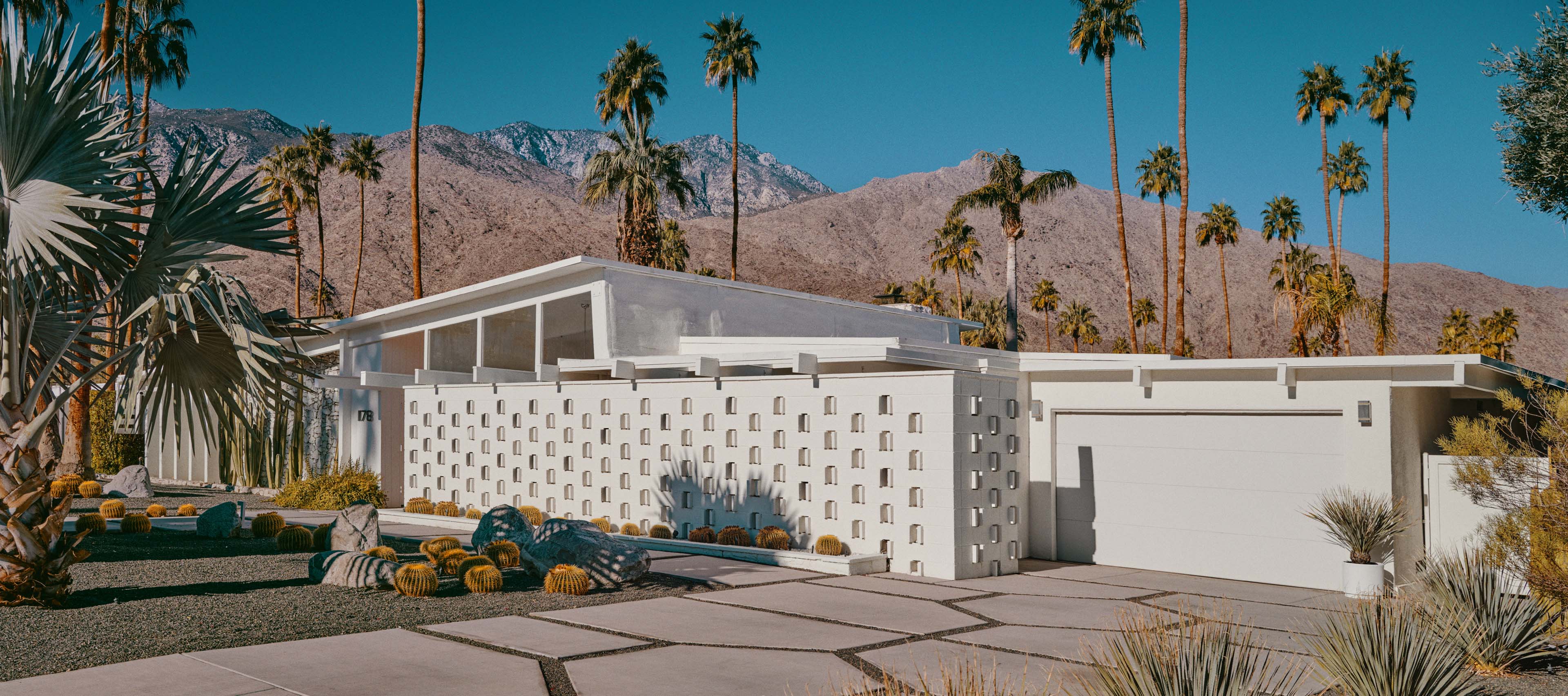 Electromobility and innovations from Mercedes-Benz A white suburban architect house with a driveway and a garage.