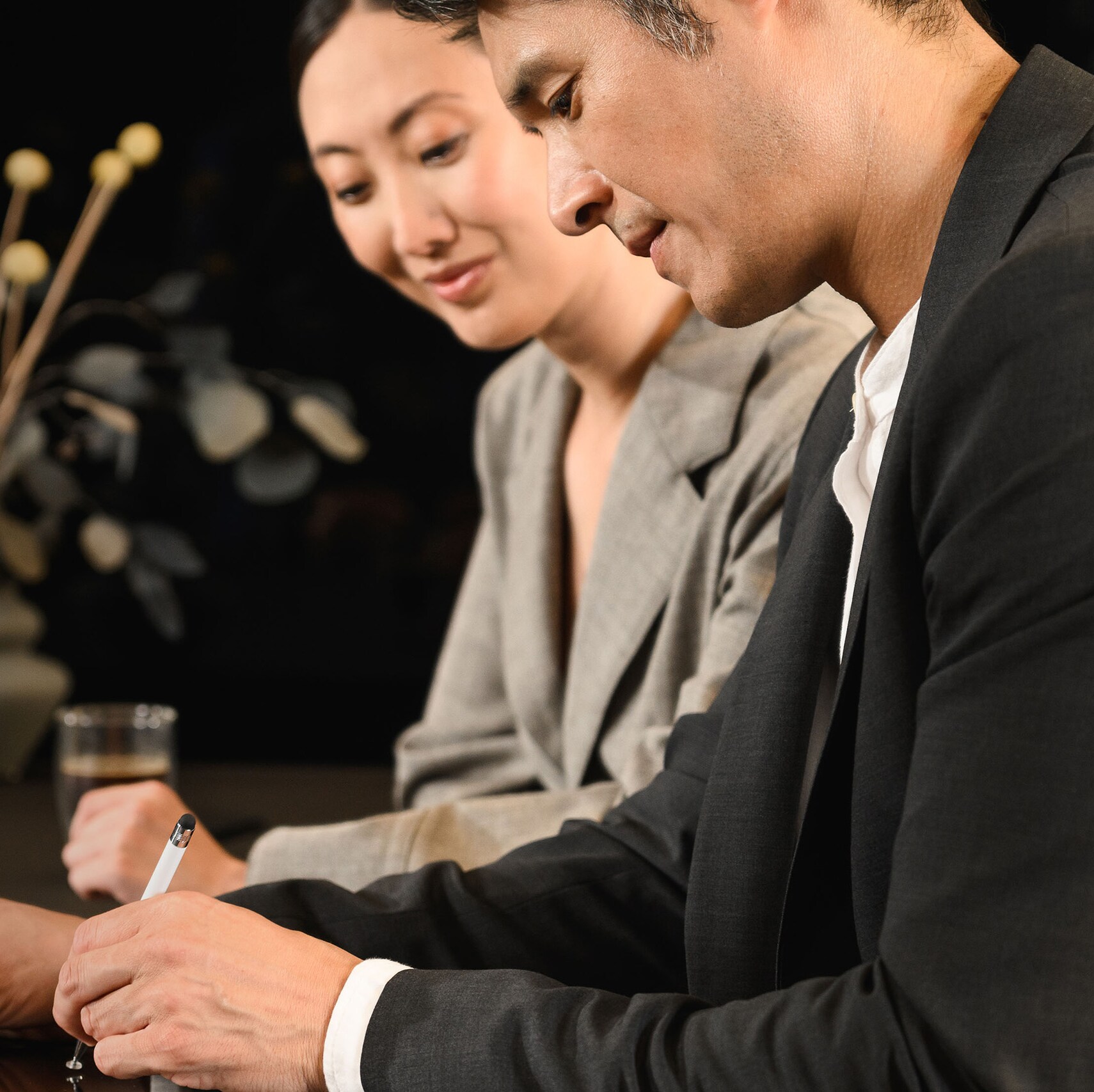Two people looking at a mobile device with one person using the device.