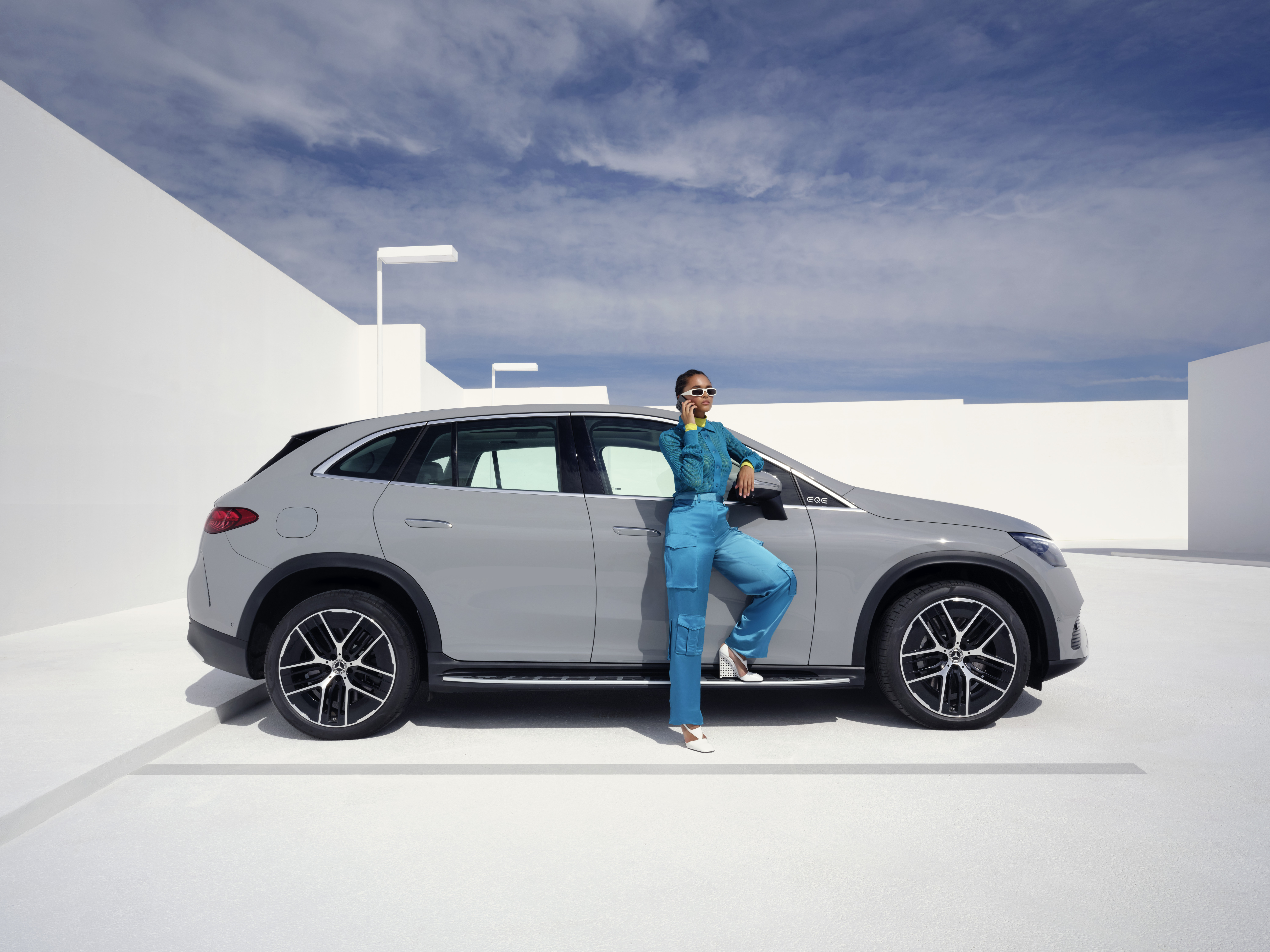 Damage and Breakdown assistance | Mercedes-Benz Woman standing in front of her Mercedes-Benz with her phone in her hand and being in a call