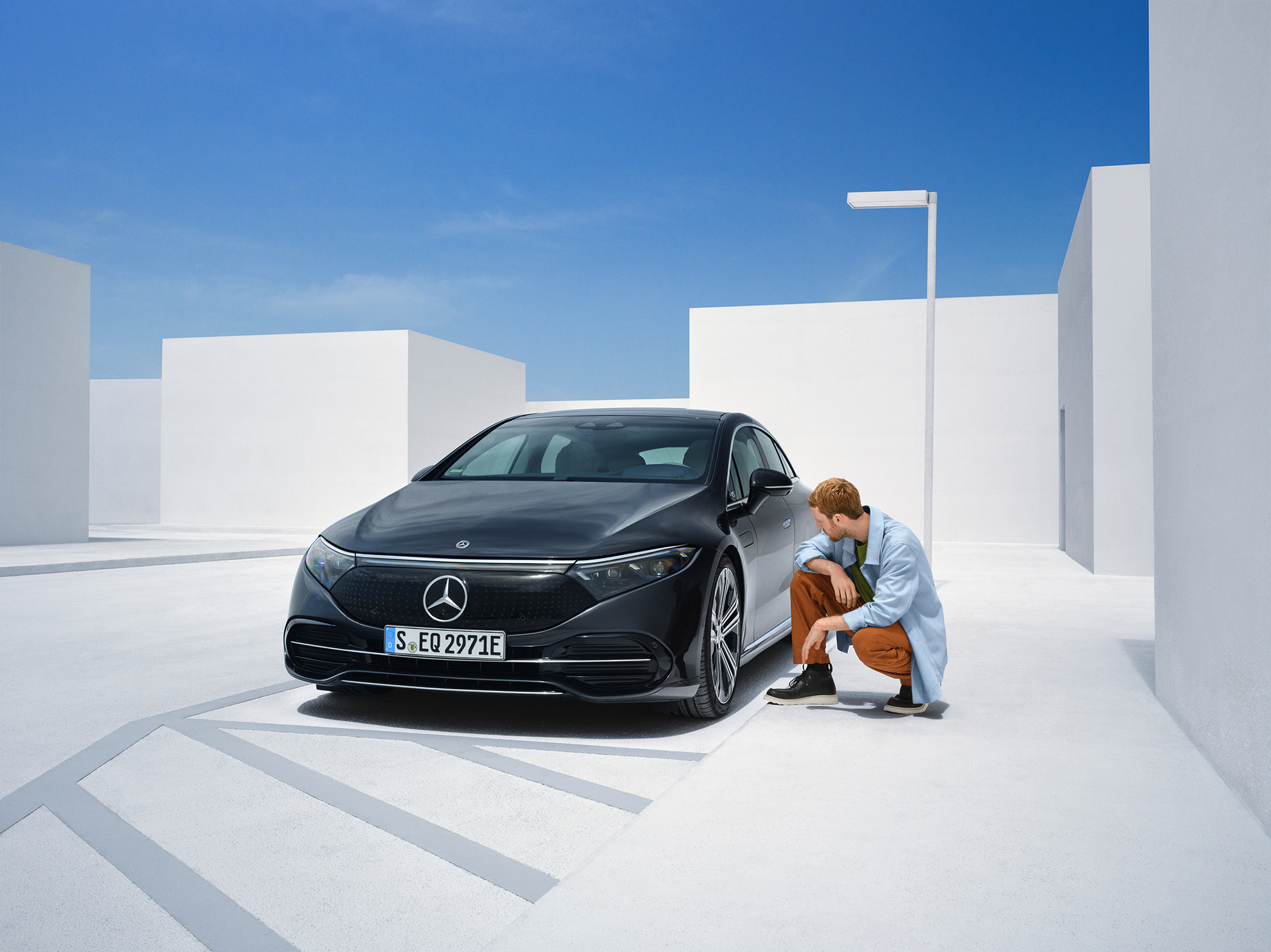 Damage Report | Mercedes-Benz Man is kneeling on the side of his Mercedes-Ben to check on it