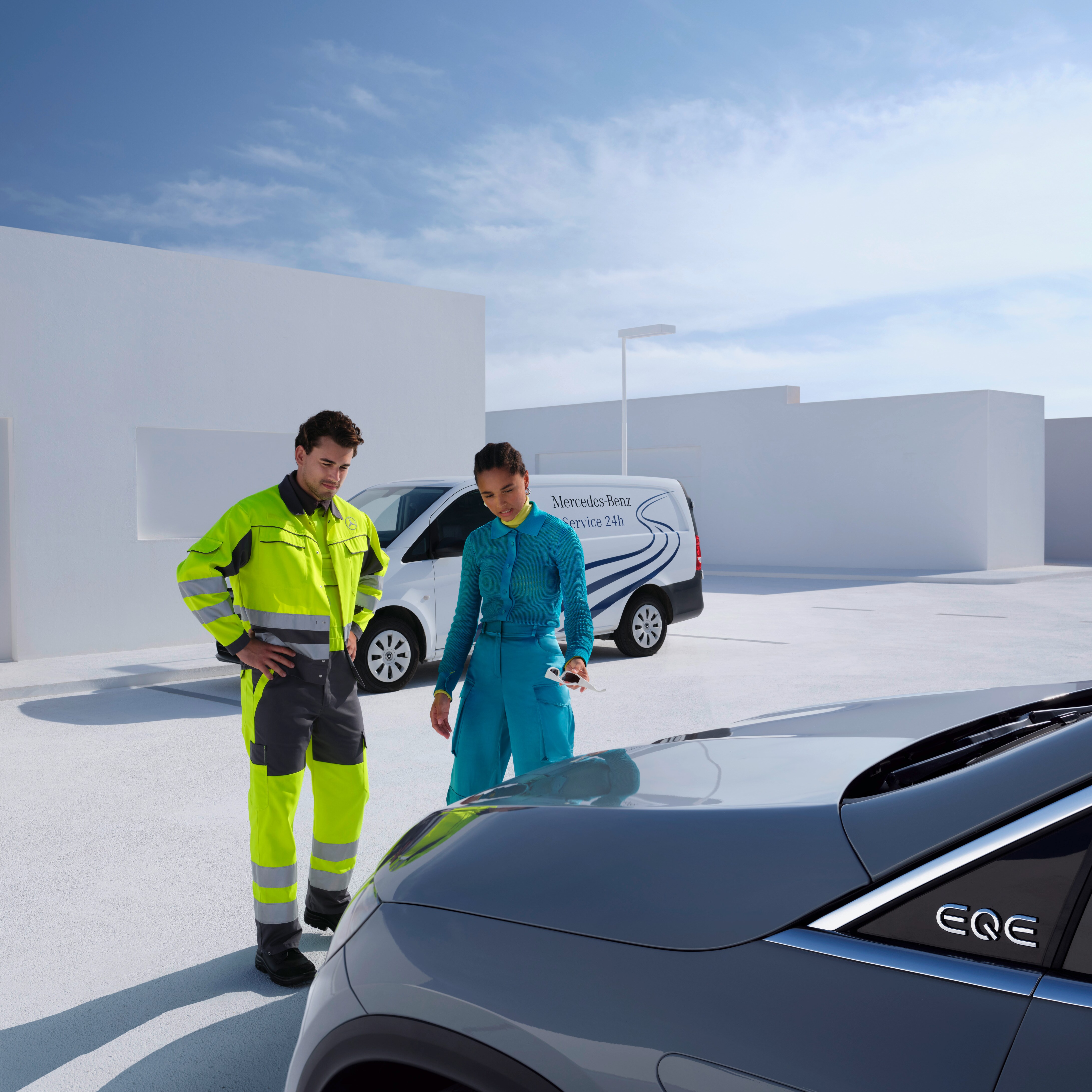A technician from the Mercedes-Benz Service team and a person looking at a Mercedes-Benz.