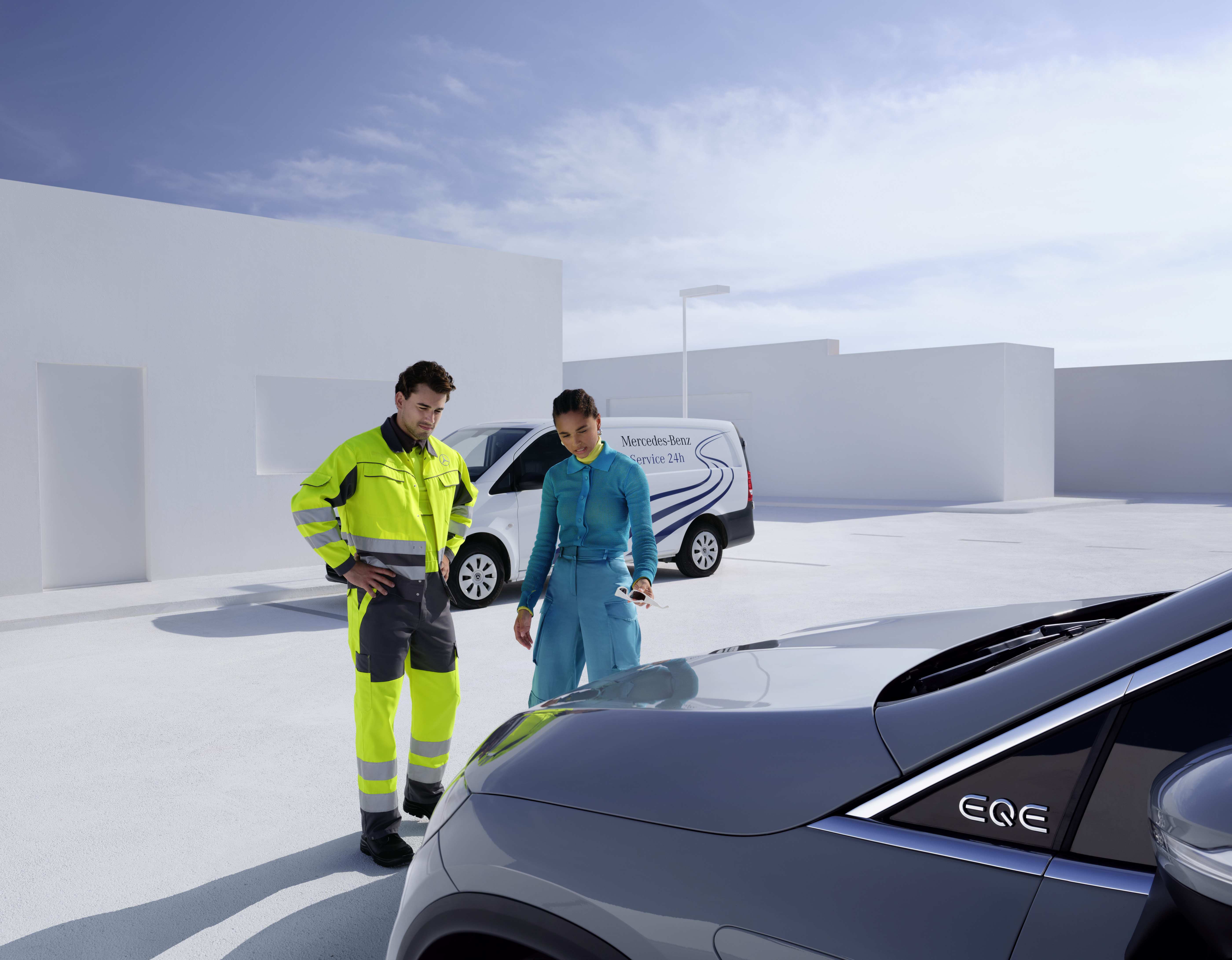 Roadside Assistance | Mercedes-Benz A technician from the Mercedes-Benz Service team and a person looking at a Mercedes-Benz.