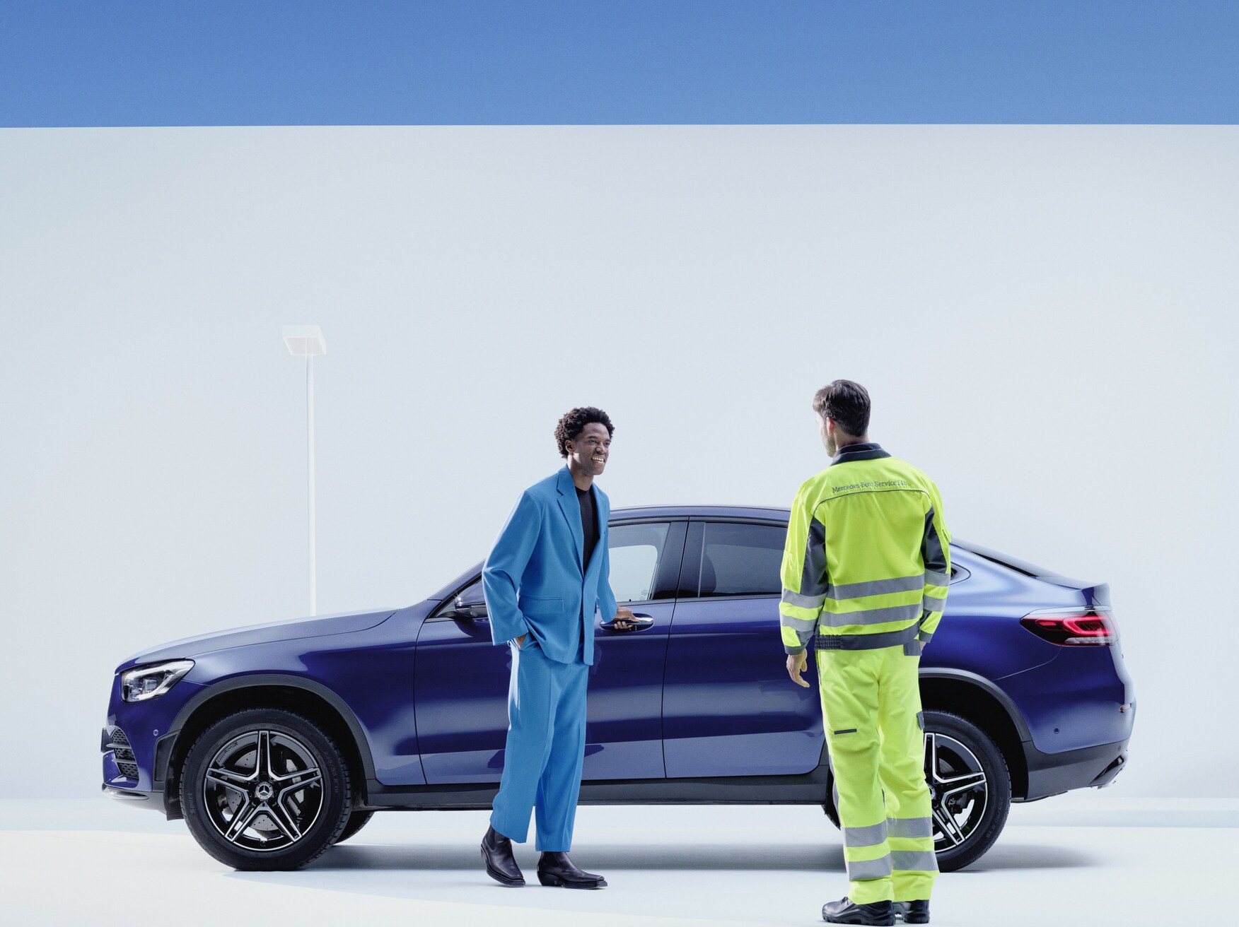 Mercedes-Benz service Person stands next to a man on the side of his Mercedes-Benz