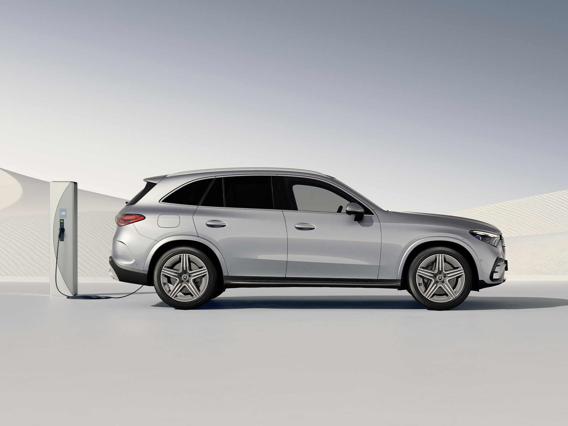 Ranges | Plug-in hybrids | Mercedes-Benz Side view of the GLC plug-in hybrid SUV at a charging station.