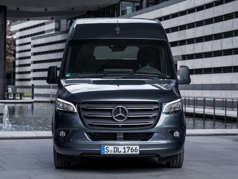 A front view of a Sprinter panel van from Mercedes-Benz parked in an urban environment.
