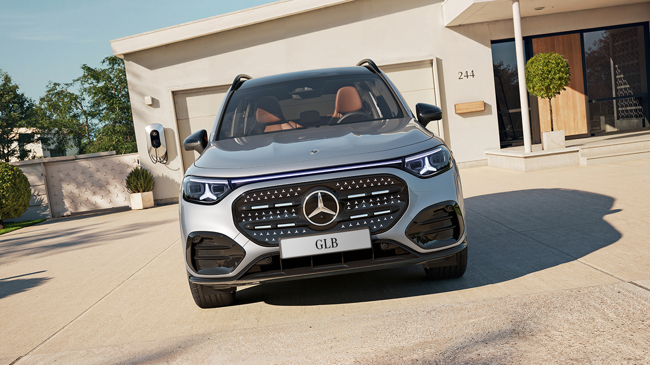 Front view of the all-new electric GLB in front a home garage.